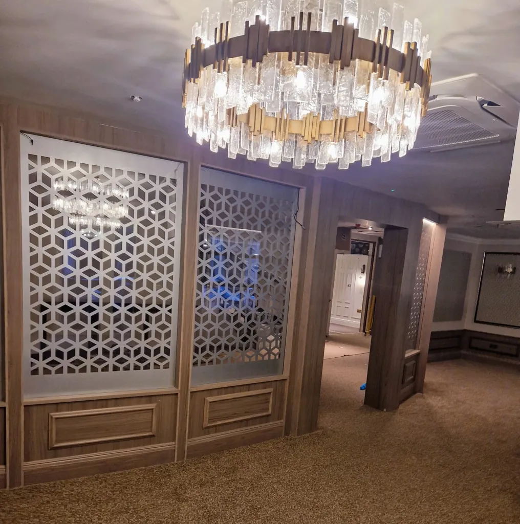 Lobby area with large feature chandelier and decorative geometric partition screens