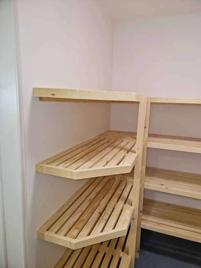 Close-up of wooden batten shelving with slatted design and timber frame supports